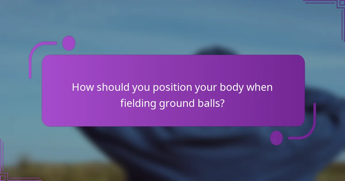 How should you position your body when fielding ground balls?